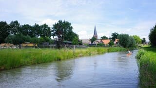Zon, wolken en een kano op het water