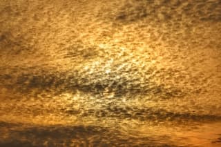 De zon verschuilt zich achter de wolken