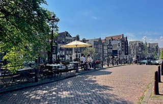 Het beste terras tafeltje van Amsterdam, midden op een brug met uitzicht op twee grachten