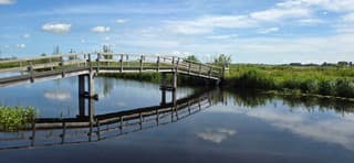 Blauw bewolkte lucht en weerspiegeling in het water 