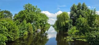 Blauw bewolkte lucht en een weerspiegeling in het water 
