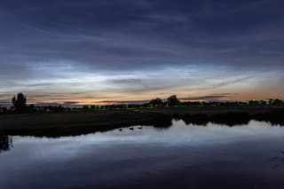 lichtende wolken boven het water