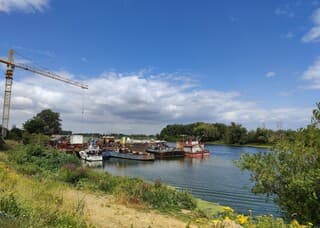 Blauwe lucht en wolken boven de Maas.