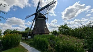 Hollands weerplaatje, molen onder lucht met stapelwolken en af en zon