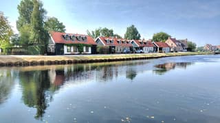 zonnig blauwe lucht huisjes reflectie 