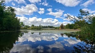 Weerspiegeling witte stapelwolken en blauwe lucht