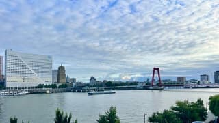 witte wolkjesluchten boven de Willensbrug over de Nieuwe Maas 
