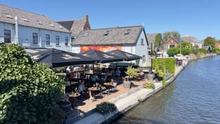 Onder de parasol op het terras langs het water. 
