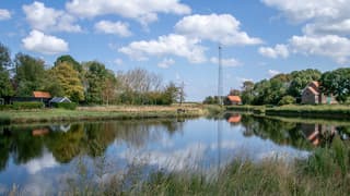 Vriendelijke bewolking weerschijnt in het water