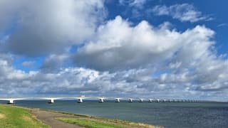 Harde wind langs de Oosterschelde met zon en wolken