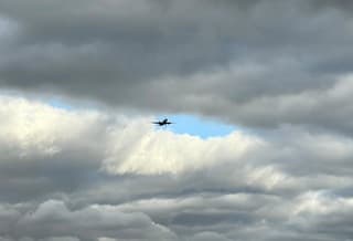 Veel donkere wolken met her en der een blauwe opening 