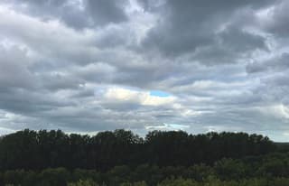 Een enkel blauw plekje in het midden van al die grijze wolken