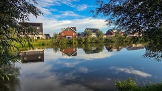 Weerschijn huizen in het water en vriendelijke bewolking 