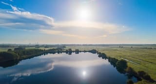 Prachtige cirruswolk boven het water in het weiland.