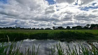 Mix van donkere wolken, blauwe lucht, zon en buien