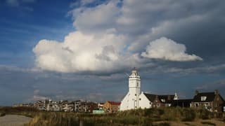 Zonnig aan kust, in het binnenland wolken