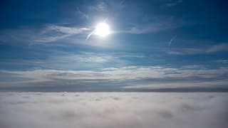 Achter de wolken/mist schijnt de zon