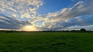 Zonsondergang, de zonnestralen komen door de donkere wolken heen