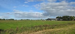 Blauw bewolkte lucht boven de Groninger landerijen 