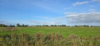 Blauw bewolkte lucht boven de Groninger landerijen 