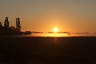 Zonsopkomst boven het mistige Friese platteland