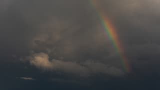 Regenboog in een grijze wolkenlucht