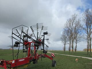 Landbouwmachine bomen grijze en blauwe luchten