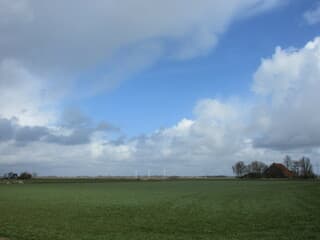De grote leegte in Friesland met wolken en blauwe lucht