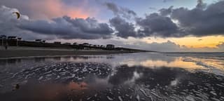 Weerspiegelde zonsondergang in het Zandvoortse zand
