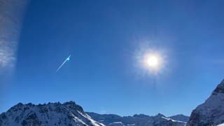 Vliegtuigstreep boven de bergen