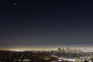 Maansverduistering boven Los Angeles met smog en sterren