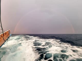 Regenboog na onweersbui op zee
