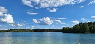 Blauw bewolkte lucht en helder blauw water