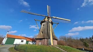 Molen bij blauwe lucht en enkele wolken 