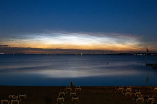 Lichtende nachtwolk vanaf het strand in Muiderberg