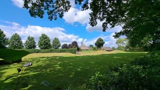 kerktoren van Rietdorp met stapelbewolking en robotgrasmaaier