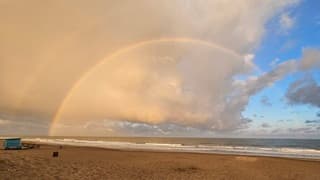 Dubbele regenboog boven de Golf van Biskaje in de vroege ochtend 