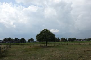 Zon en wolken, kans op een bui.