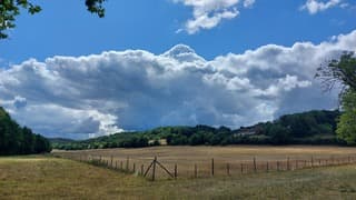 hitte in de Dordogne, donkere wolen boven hooiveld