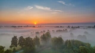 Zonsopkomst boven een dun laagje mist. 