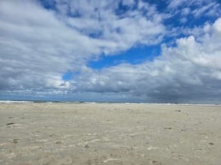 Wolken met blauwe lucht op het strand. Buren Ameland