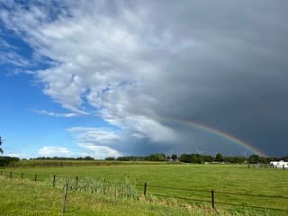 Regenboog, donkere lucht en opklaringen 