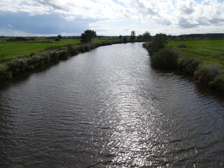 Zon achter de wolken en wind op het water.