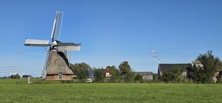 Blauwe lucht zon en bewolking boven Groninger molen