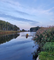 Roeien met de maan op de achtergrond.