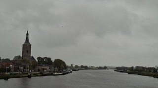 Grijs, grauw, en regenbui zichtbaar in de verte