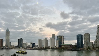 Hoog in de lucht staat bij opkomst van de zon nog de maan 