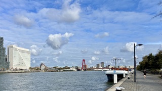 Allerlei soorten bewolking aan blauwe lucht boven de Nieuwe Maas 