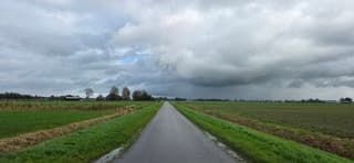 Donkere regenwolken en regen boven de Groninger landerijen 