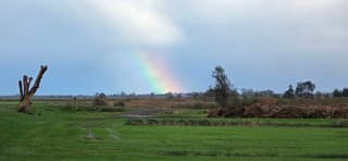 Regen regenwolken en een regenboog eind van de middag 
